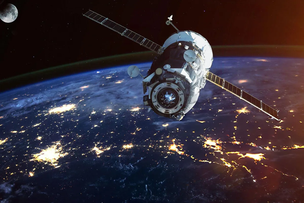 A satellite orbiting Earth with city lights below